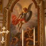 ...� collocata una tela raffigurante San Michele in abiti blu e porpora che sconfigge i demoni, realizzata nel 1895 dal pittore barese Domenico Battista
